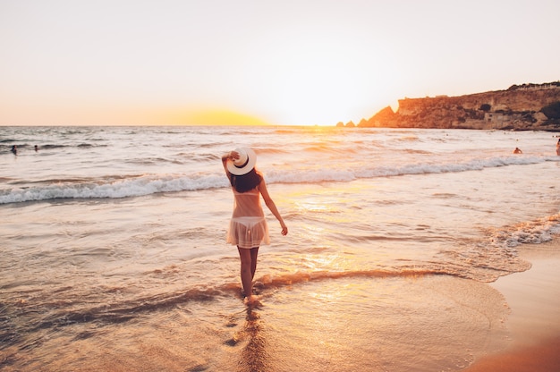 Mujer caucásica camina a lo largo de la costa hermosa