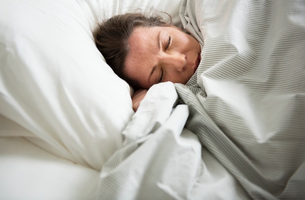 Mujer caucásica durmiendo en la cama