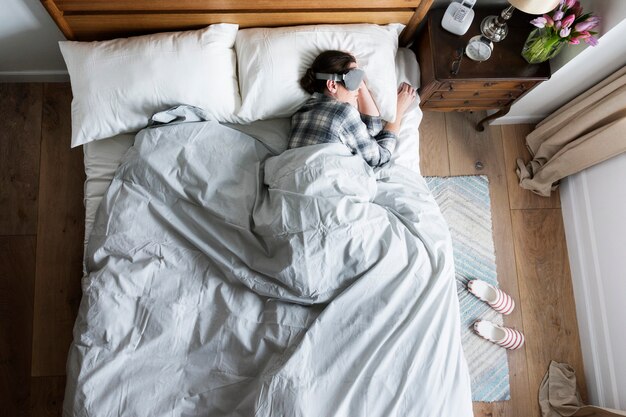 Mujer caucásica durmiendo con una cubierta de ojo en