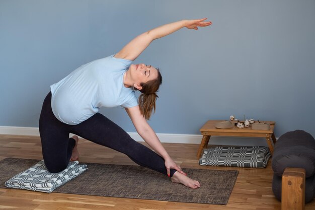 Mujer caucásica embarazada de pie en yoga asana