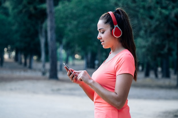 Mujer caucásica escuchando música en un parque