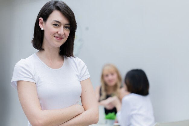 mujer caucásica de felicidad de pie con confianza con personas reunión de fondo