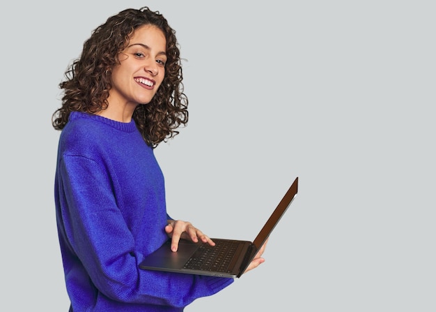 Mujer caucásica feliz buscando en la computadora portátil