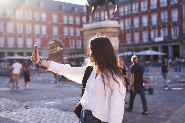 La mujer caucásica feliz se está tomando un selfie