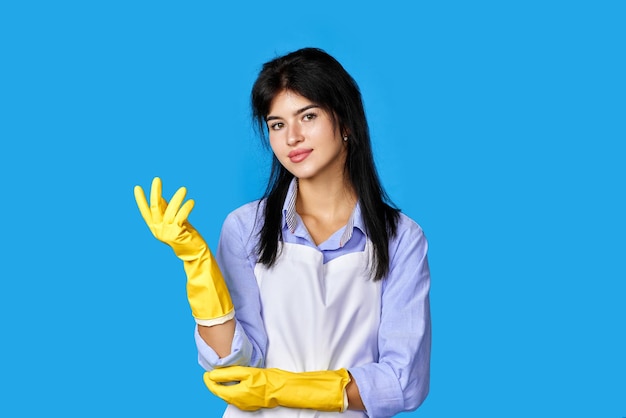 Mujer caucásica en guantes de goma aislado sobre fondo azul.