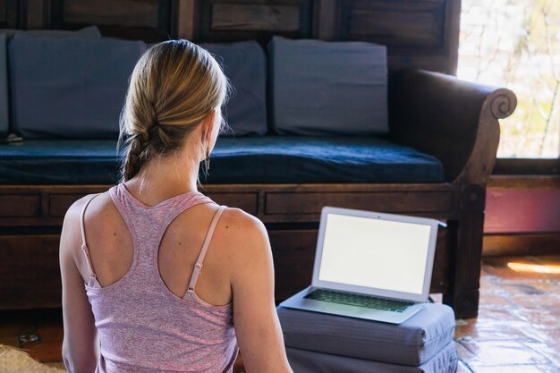 Mujer caucásica irreconocible viendo una laptop en casa.