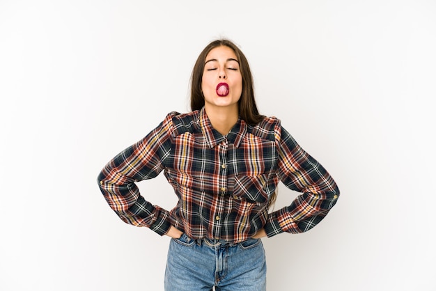 Mujer caucásica joven aislada en blanco lengua divertida y amigable.