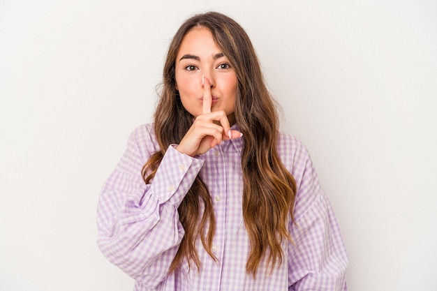 Foto mujer caucásica joven aislada de fondo blanco guardando un secreto o pidiendo silencio.