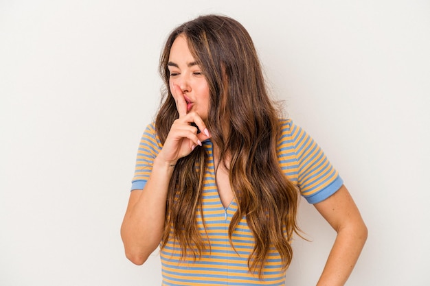 Mujer caucásica joven aislada de fondo blanco guardando un secreto o pidiendo silencio.