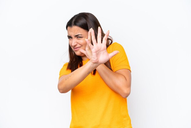 Foto mujer caucásica joven aislada en fondo blanco nerviosa estirando las manos hacia el frente