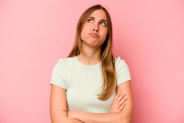 Mujer caucásica joven aislada de fondo rosa cansada de una tarea repetitiva