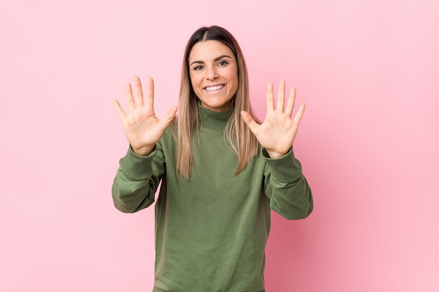 Mujer caucásica joven aislada mostrando el número diez con las manos.