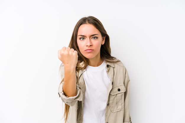 Mujer caucásica joven aislada mostrando el puño con expresión facial agresiva.