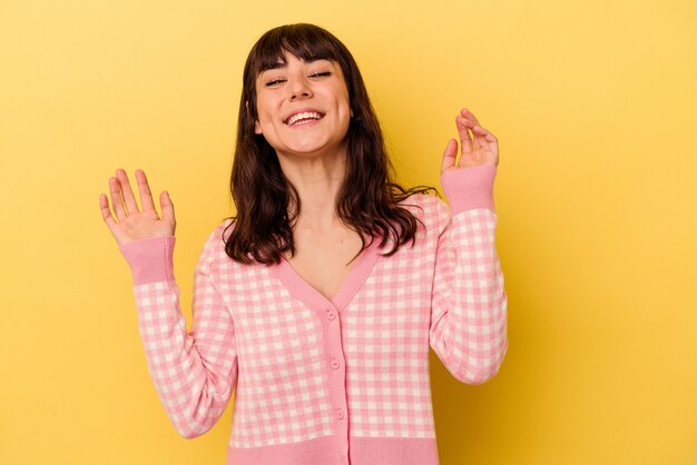 Foto mujer caucásica joven aislada en la pared amarilla alegre riendo mucho. concepto de felicidad.