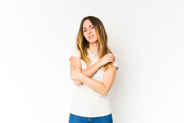 Foto mujer caucásica joven aislada en la pared blanca masajeando el codo, sufriendo después de un mal movimiento.