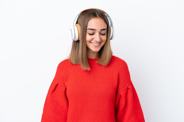 Mujer caucásica joven aislada sobre fondo blanco escuchando música