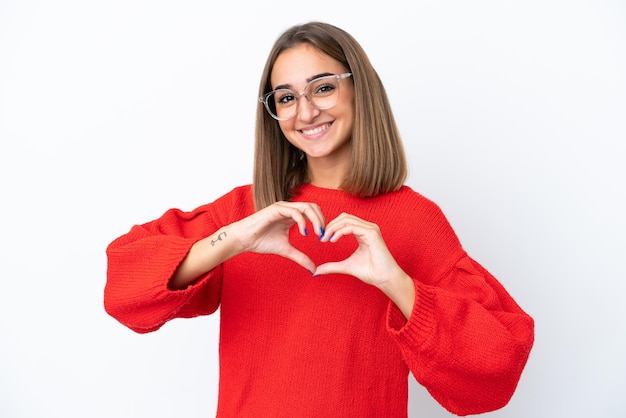 Mujer caucásica joven aislada sobre fondo blanco con gafas haciendo corazón con las manos