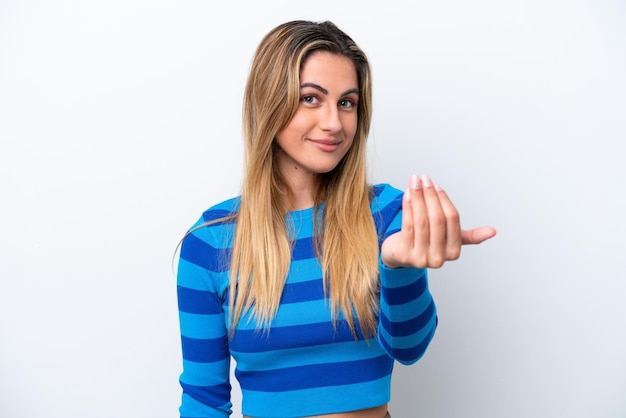 Foto mujer caucásica joven aislada sobre fondo blanco invitando a venir con la mano feliz de que hayas venido