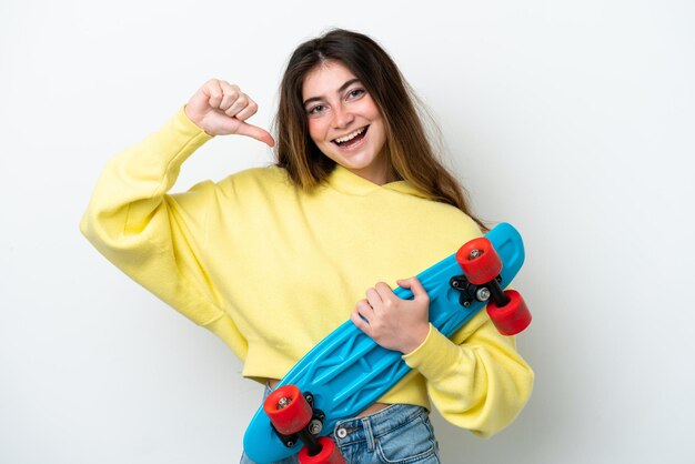 Mujer caucásica joven aislada sobre fondo blanco con un patín con expresión feliz