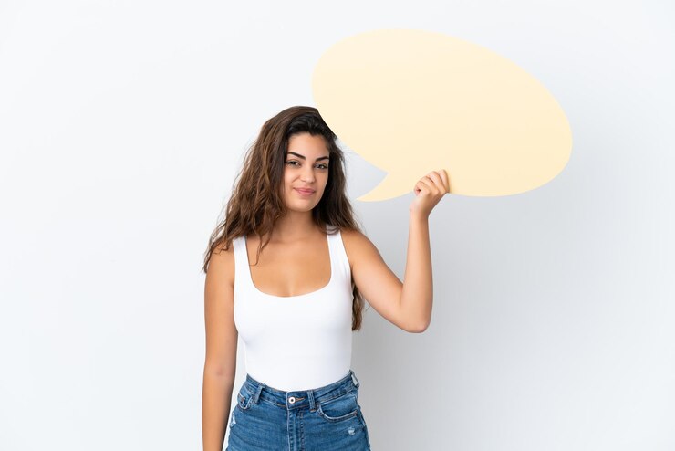 Foto mujer caucásica joven aislada sobre fondo blanco sosteniendo un bocadillo de diálogo vacío