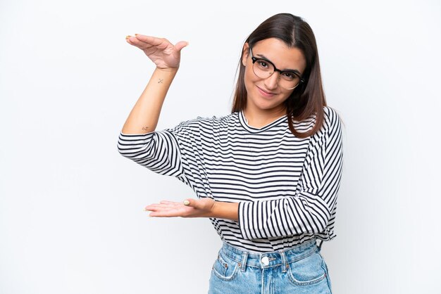 Mujer caucásica joven aislada sobre fondo blanco sosteniendo copyspace para insertar un anuncio