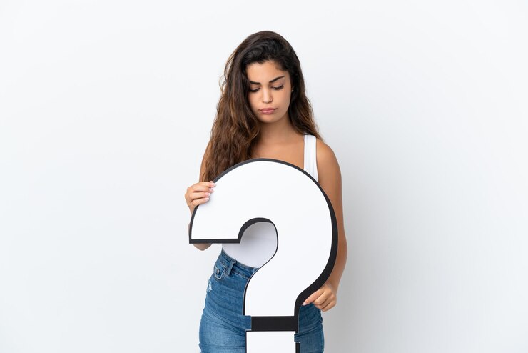 Foto mujer caucásica joven aislada sobre fondo blanco sosteniendo un icono de signo de interrogación