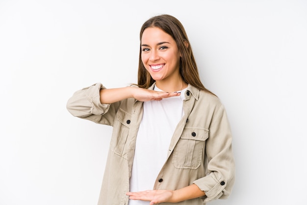 Mujer caucásica joven aislada sosteniendo algo con ambas manos, presentación del producto.