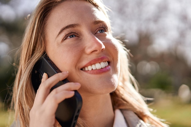 Mujer caucásica joven alegre que habla en el teléfono