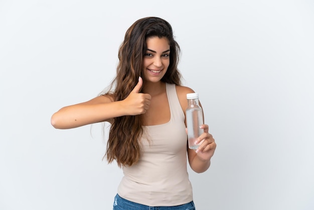 Mujer caucásica joven con una botella de agua aislada sobre fondo blanco dando un gesto de aprobación