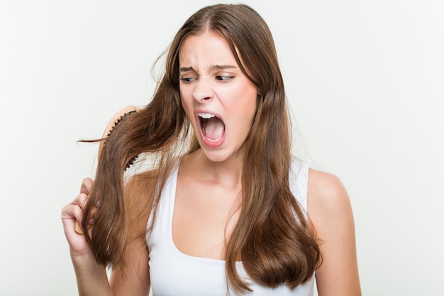 Mujer caucásica joven cepillando su cabello