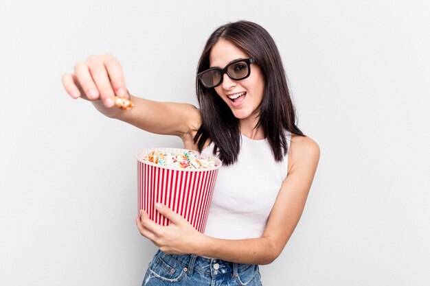 Mujer caucásica joven comiendo palomitas de maíz aislado sobre fondo blanco.