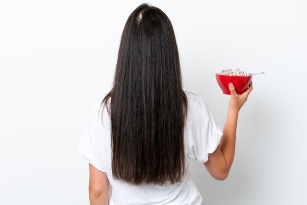 Foto mujer caucásica joven desayunando leche aislada de fondo blanco en posición trasera