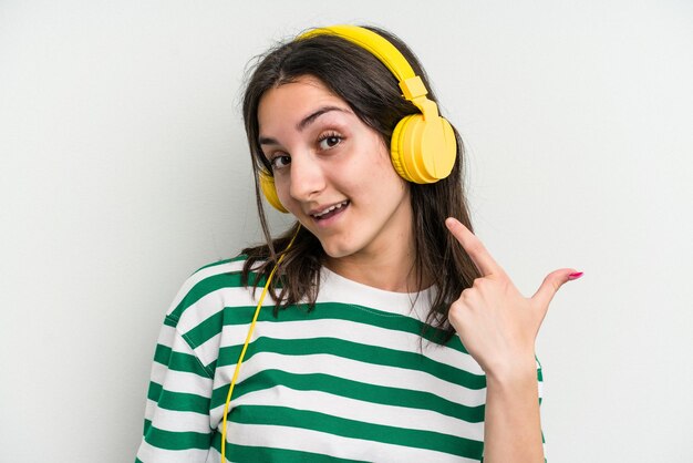 Mujer caucásica joven escuchando música aislado sobre fondo blanco.