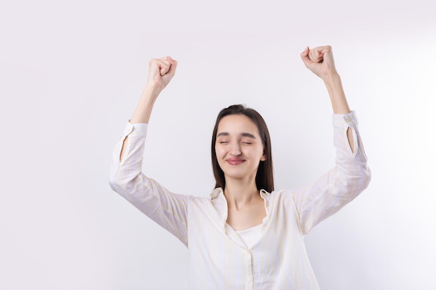 Mujer caucásica joven feliz con una camisa blanca puño cerrado de alegría Éxito y felicidad del trabajo Victoria de la persona exitosa