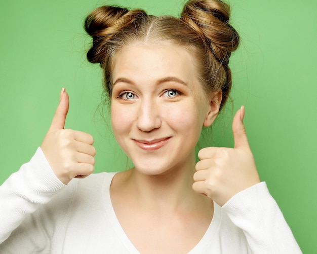 Mujer caucásica joven feliz haciendo señal de pulgar hacia arriba y sonriendo alegremente