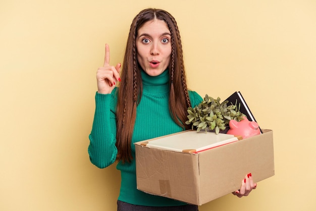 Mujer caucásica joven haciendo un movimiento aislado sobre fondo amarillo con una idea, concepto de inspiración.