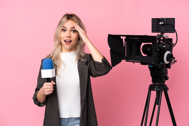 Mujer caucásica joven hermosa reportero sobre pared rosa