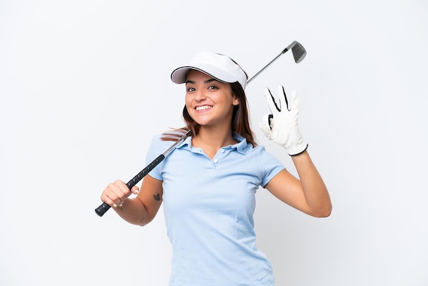 Foto mujer caucásica joven jugando al golf aislado sobre fondo blanco mostrando signo ok con los dedos