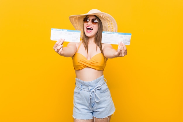 Mujer caucásica joven lista para ir a la playa con boletos aéreos