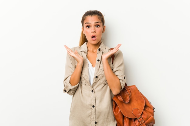 Mujer caucásica joven lista para un viaje sorprendida y conmocionada.