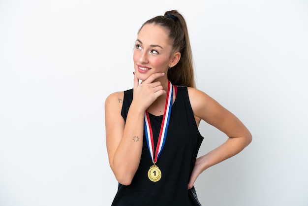 Mujer caucásica joven con medallas aislado sobre fondo blanco mirando hacia el lado