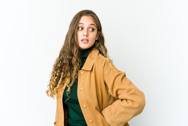 La mujer caucásica joven mira a un lado sonriente, alegre y agradable.