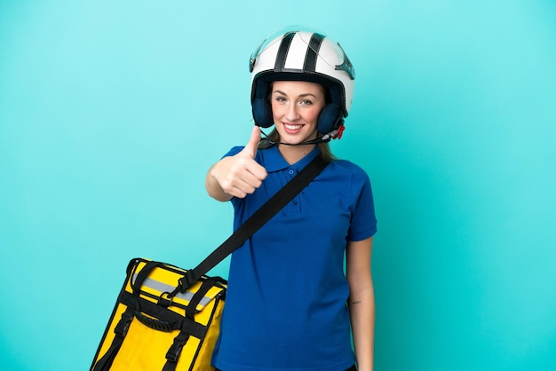 Mujer caucásica joven con mochila térmica aislada de fondo blanco con los pulgares hacia arriba porque ha sucedido algo bueno