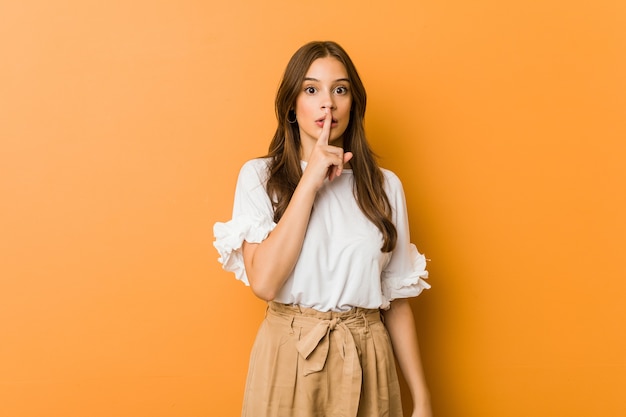 Mujer caucásica joven que guarda un secreto o que pide silencio.