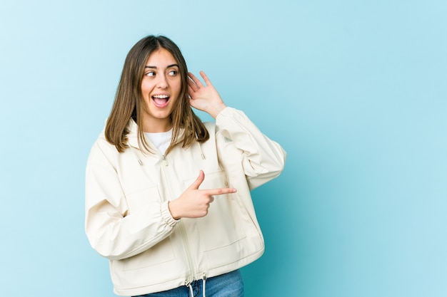 Mujer caucásica joven que intenta escuchar un chisme.