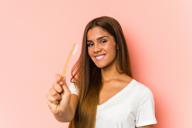 Mujer caucásica joven que limpia sus dientes con un cepillo de dientes