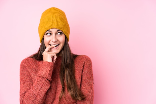 La mujer caucásica joven que llevaba un gorro de lana se relajó pensando en algo mirando un espacio de copia.