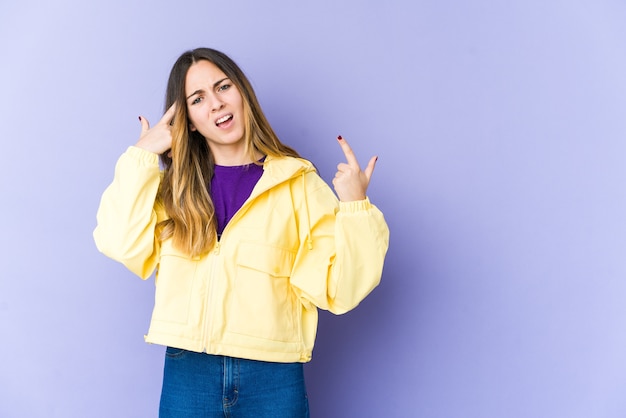 Mujer caucásica joven que muestra un gesto de decepción con el dedo índice.