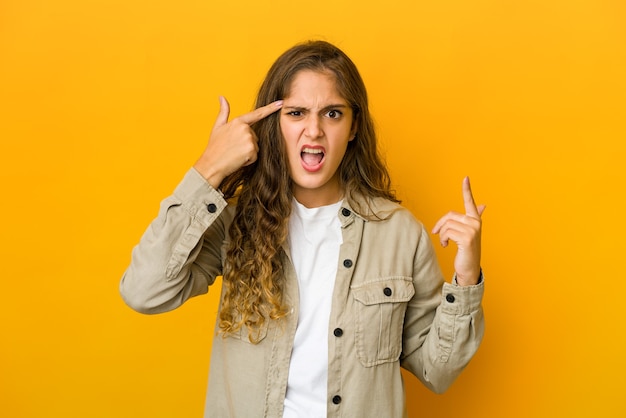 Mujer caucásica joven que muestra un gesto de decepción con el dedo índice.