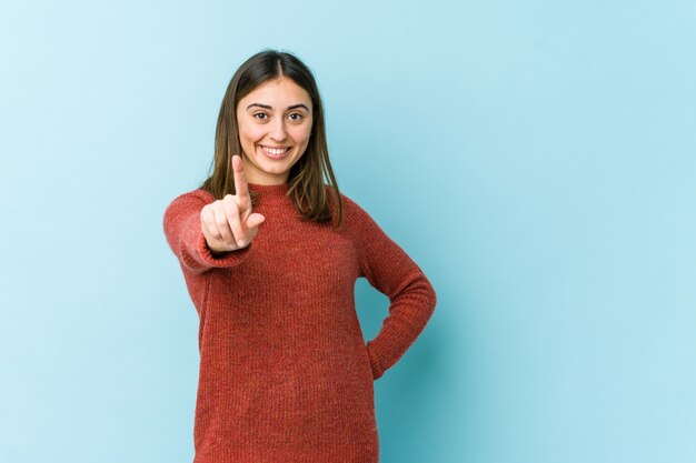 Mujer caucásica joven que muestra el número uno con el dedo.